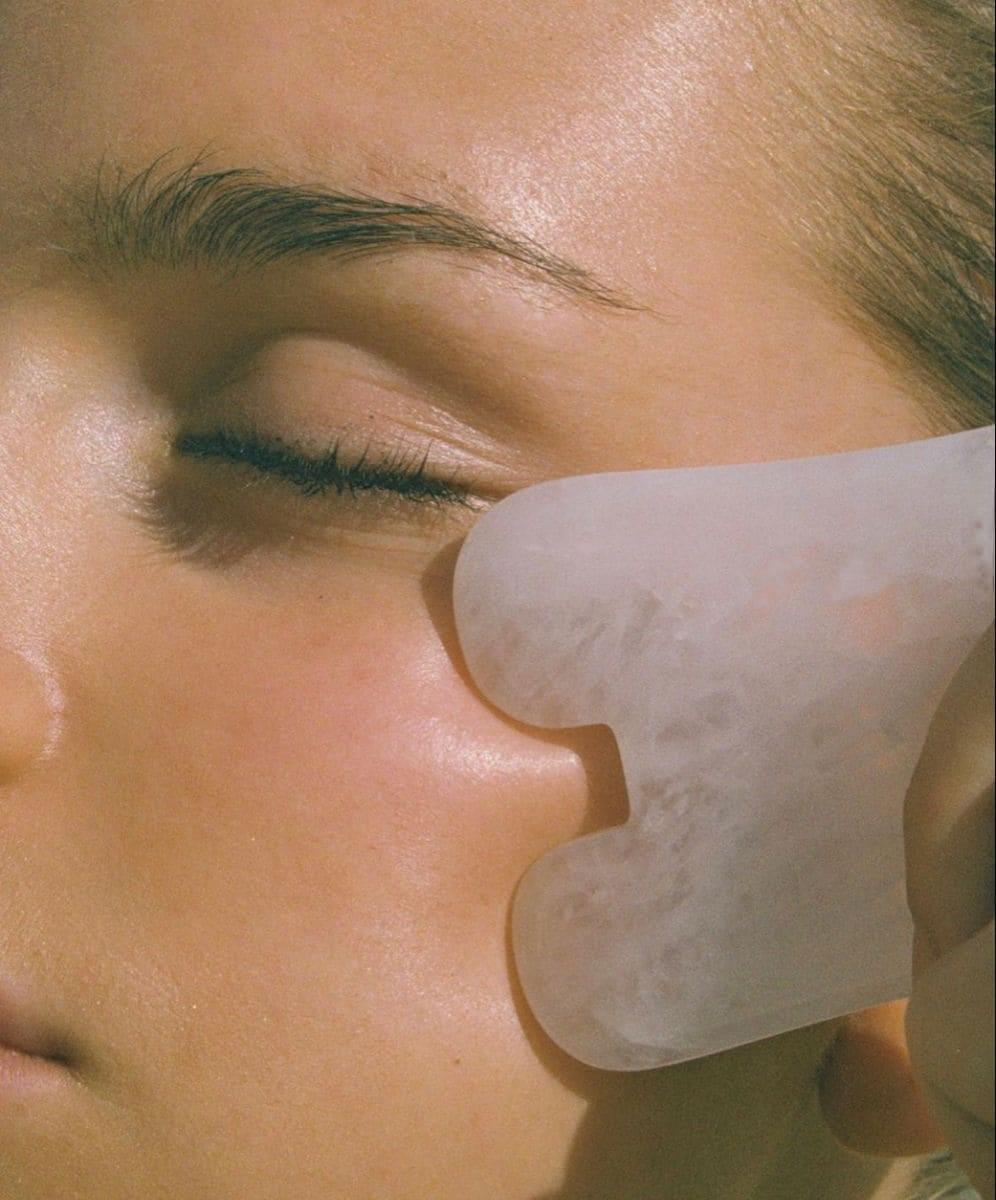Realizando masaje facial Gua Sha